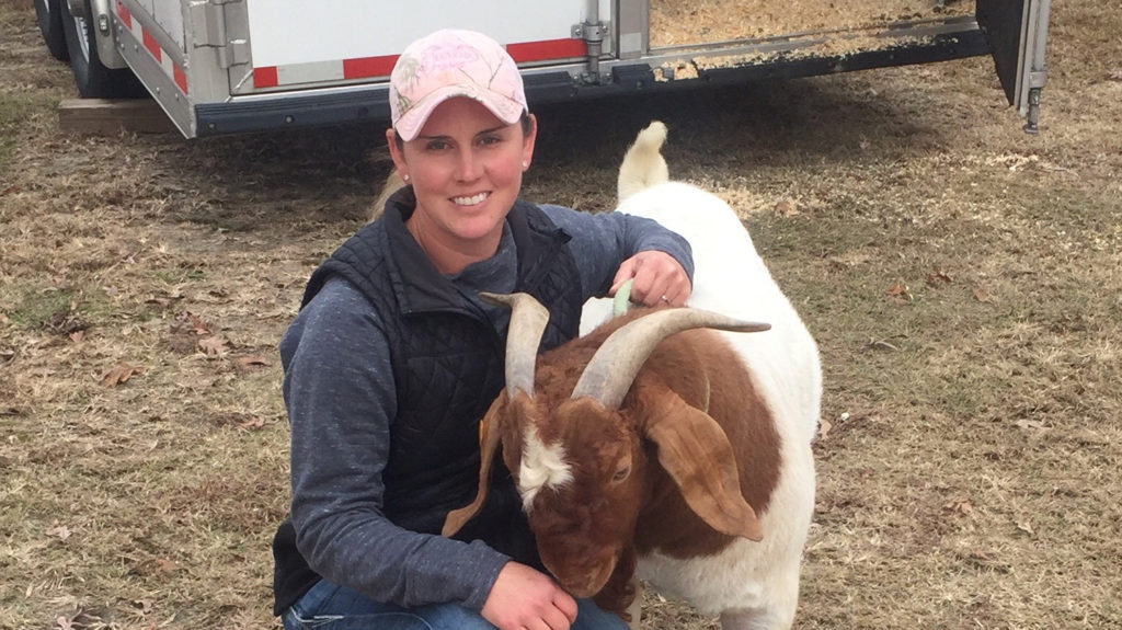 Jennifer Harrison with a horned brown and white goat